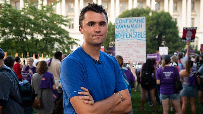 Charlie Kirk in a t-shirt with arms folded